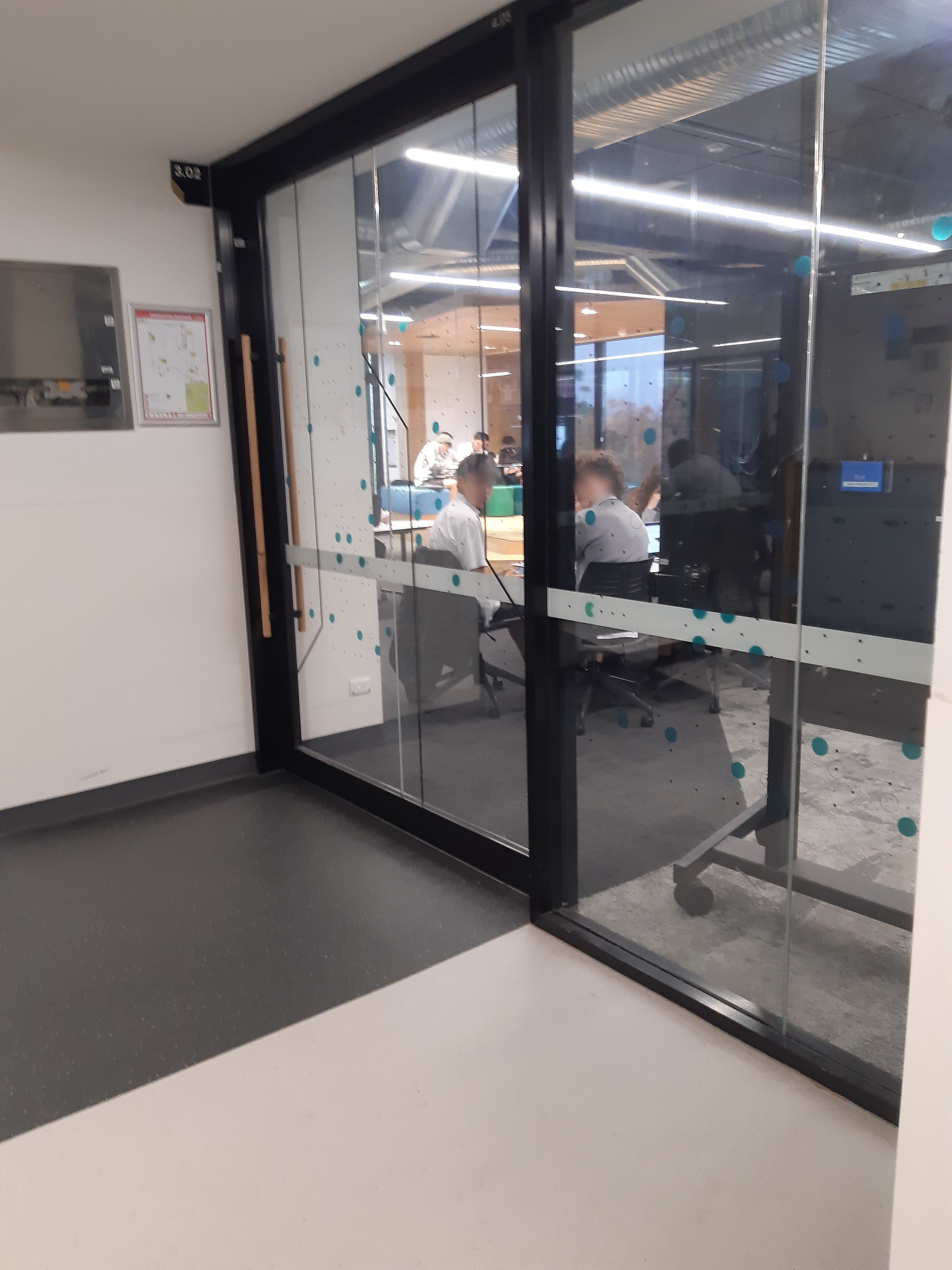 students photgraphed through a glass wall